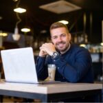 Empresário na mesa com o notebook aberto.